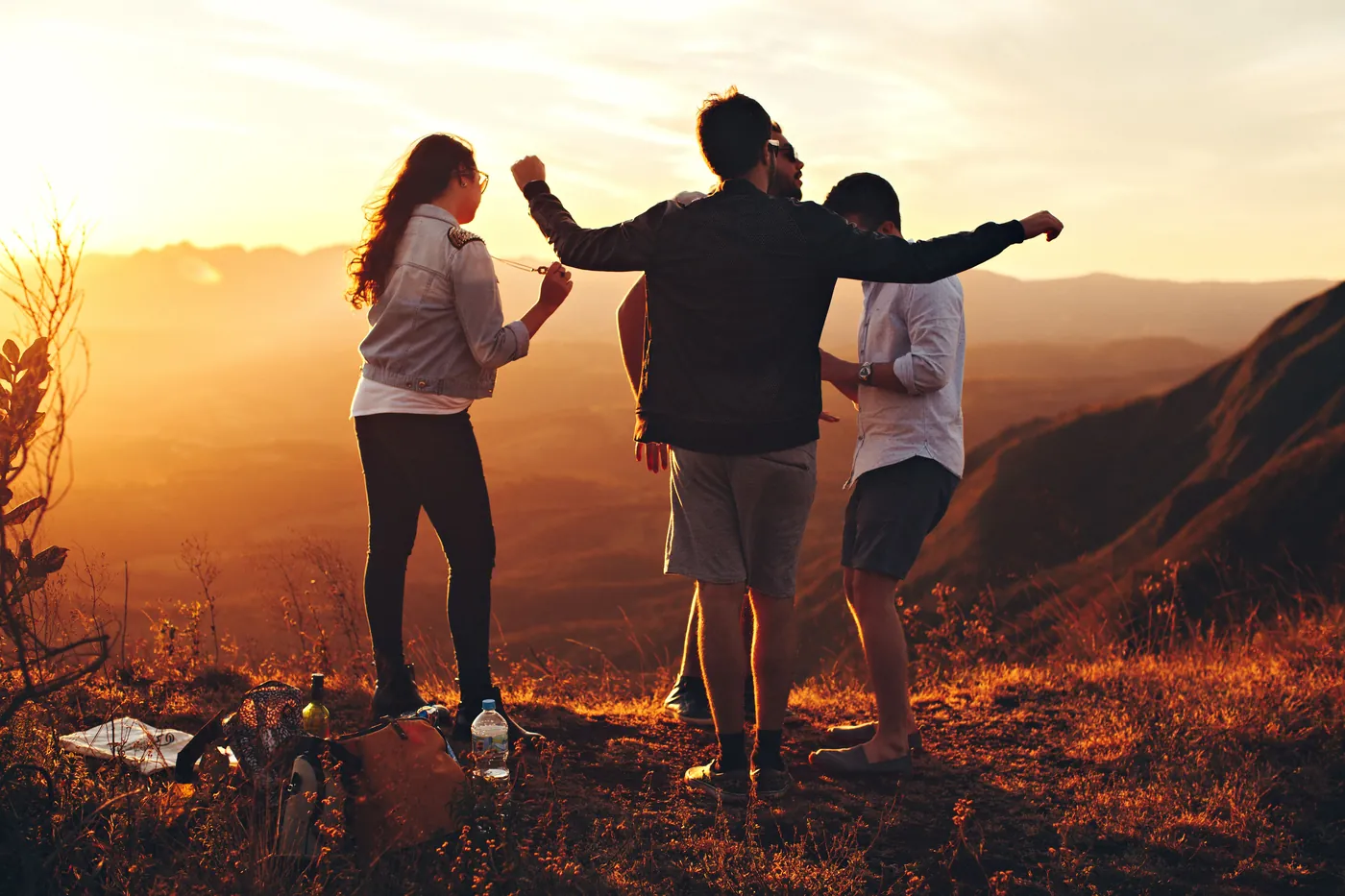 Friends together at sunset on a hill